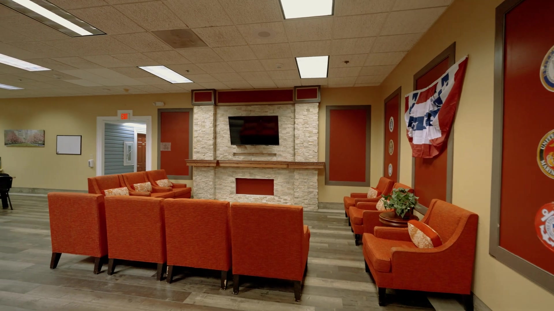 Cozy resident lounge with stone fireplace at Colonial Gardens memory care facility in Lauderhill Florida